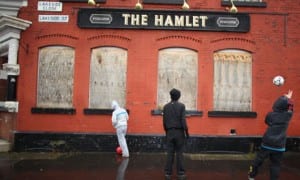 Young people play football against a boarded-up pub in Gorton, Manchester. Absolute poverty among children rose by 300,000 in the last year. Photograph: Christopher Furlong/Getty Images