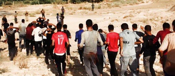 This image posted on a militant website on Saturday, June 14, 2014, which was provided by AP and has not been verified by NBC News, appears to show militants from the al-Qaeda-inspired Islamic State of Iraq and al-Sham (ISIS) leading captured Iraqi soldiers wearing plain clothes to an open field moments before shooting them in Tikrit, Iraq. The caption on this image, in Arabic, said, "They walking to death by their foot."