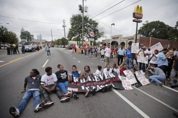   Protesters block Atlanta’s Ponce de Leon Avenue on Thursday outside a McDonald’s restaurant. They were demanding that fast food chains pay workers at least $15 an hour. AP/David Goldman