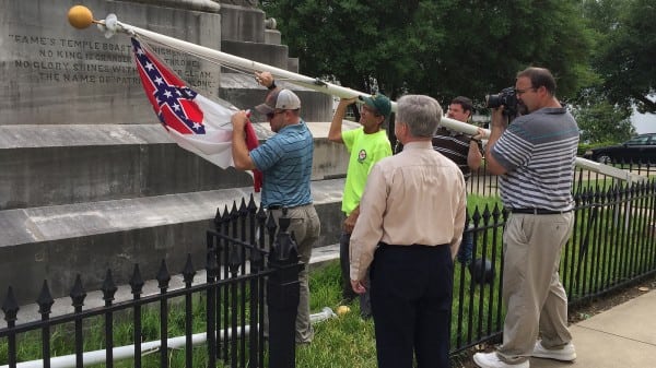 State workers take down a Confederate national flag on the grounds of the state Capitol on Wednesday in Montgomery, Ala.