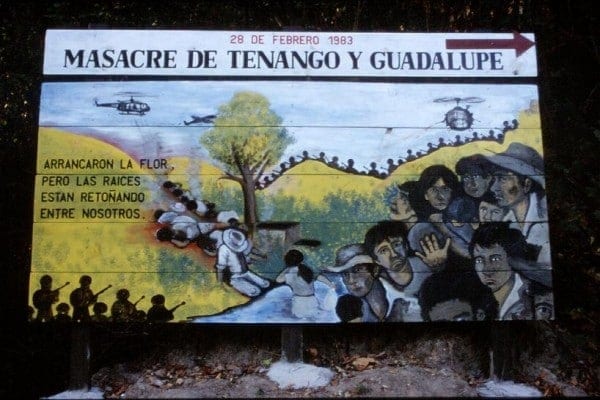 A billboard serving as a reminder of one of many massacres that occurred during the Civil War in El Salvador. The Castilian inscription to the left reads in English: "They tore out the flower, but the roots are returning among us." (Dave Watson)